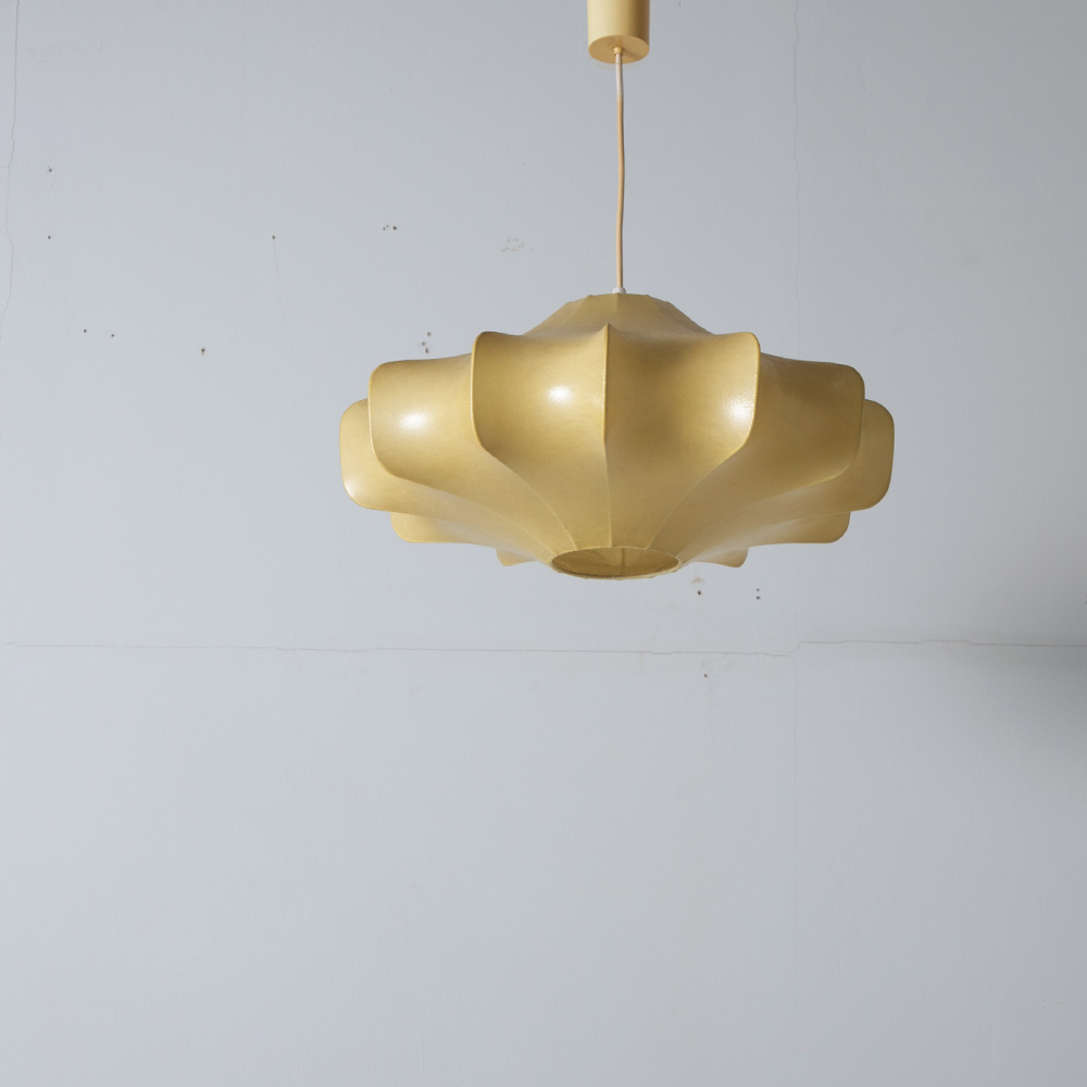 Flower Shape Cocoon Pendant Lamp by Achille Castiglioni for FLOS
Italy , 1960s - 1980s
イタリアを代表するデザイナー　Achille Castiglioni（アッキーレ・カスティリオーニ）とピエール・ジャコモ・カステリーニの兄弟によって1960年代にデザインされたコクーンランプ。
シェードは、スチールのフレームに吹き付けられた、繊維状の膜に覆われています。
現行品にはないモデルとなっており、ヴィンテージ特有の経年変化による色合いが美しく、コンディションも良好です。
配線交換後のお渡しとなります。コードの長さ、色味はご希望のサイズでオーダー可能です。
