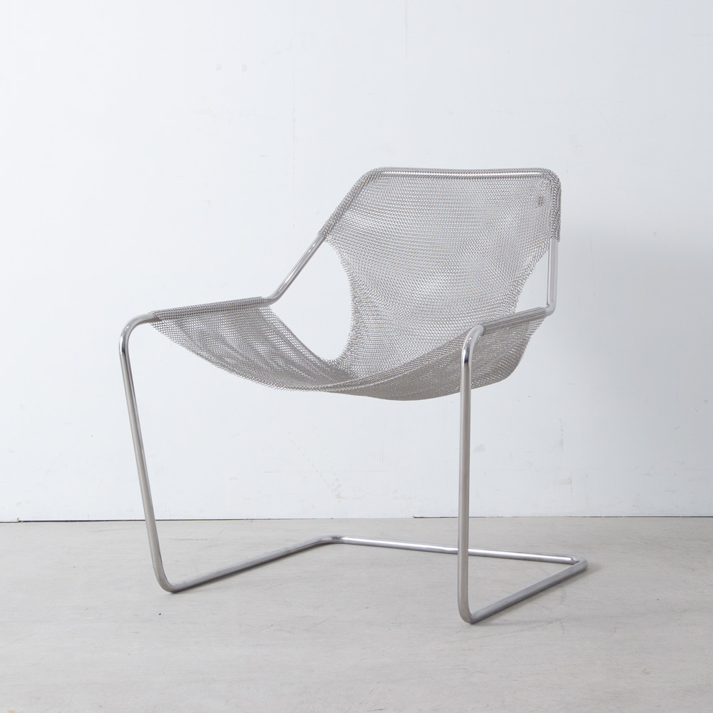 Paulistano Mesh Chair by Paulo Mendes da Rocha for OBJEKTO
Brazil , New Edition
ブラジルを代表する建築家 Paulo Mendes da Rocha（パウロ・メンデス・ダ・ロシャ）によってデザインされた Paulistano（パウリスタノ）アームチェアスチールメッシュモデル。
サンパウロの競技場を建築する際にデザインされ、2007年にはニューヨーク近代美術館（MoMA）の永久コレクションにも加わった名作椅子です。
2010年、Le Labo Design とのコラボレーションにより、スチール製のメッシュカバーを備えたこのモデルが発表されました。
1本の細いスチールバーと洋服のように取り外しが可能な美しいステンレスメッシュ材によって構成された無駄のない構造は、美しいフォルムと耐久性を兼ね備え、包み込まれるような想像以上の座り心地を与えてくれます。
