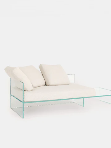 イタリアの建築家・デザイナーのPiero Lissoni（ピエロ・リッソーニ）によって2022年に発表されたTête-à-tête（テテ・ア・テテ）ソファ。
厚さ19mmのエクストラライトガラスを使用し成形、強化、UV接着されています。
クッションの中綿はグースダウンのような柔らかさで、海洋から回収されたプラスチックを再利用した低刺激性／無農薬／環境適合素材でできています。
サイドテーブルがシートに一体化されたタイプ（右側または左側）と、対面シートの2タイプからお選びいただけます。
サイドテーブルのタイプには取り外し可能なシートクッション1つとバッククッションが2つ、対面型にはシートクッション1つとバッククッションが4つ付属します。
ご要望に応じて、バッククッションを追加することも可能です。
