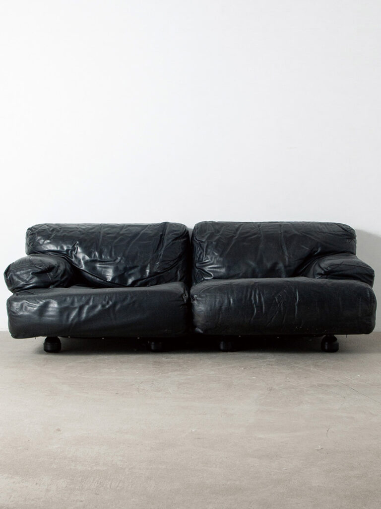 ‘Fiandra’ Sofa by Vico Magistretti for Cassina in Leather
Italy , 1970s
イタリア人デザイナー Vico Magistretti(ヴィコ・マジストレッティ)によって、1975年にCassina(カッシーナ)社のためにデザインされた 'Fiandra'(フィアンドラ)ソファ。
伝統的なテキスタイル産業が有名な、ベルギー北部に位置するフランダース地方(イタリア語でFiandra)からインスピレーションを受けデザインされました。
ヴォリューム感のあるボディと丸みを帯びたプリミティブな脚部とのコントラストが印象的で、床との間に生まれる空間が、重厚ながらも軽やかな印象を巧みに演出しています。