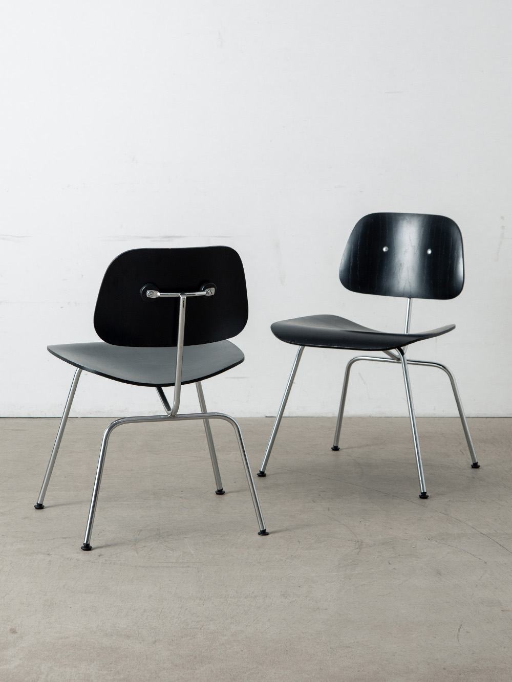 ‘DCM‘ Chair by Charles & Ray Eames for Herman Miller in Plywood and Stainless
America , 1960s
Charles & Ray Eames(チャールズ&レイ・イームズ)によって、Herman Miller(ハーマン・ミラー)社のために1946年にデザインされた ‘DCM’ チェア。
DCMとは Dining Chair Metal Legs の略で、プライウッドのしなやかな曲線が人間工学に基づく快適な座り心地を生み出します。
通常のモデルでは背板とフレームを接着剤のみで固定していますが、こちらの個体はリペア時に仕様が変更され、接着剤に加えてビスも併用しています。そのため、背板の表面にも鋲が見える仕様になっています。
ニューヨーク近代美術館(MoMA)のパーマネントコレクションに選ばれ、米国「TIME」誌からは「20世紀で最も優れたデザイン」と評されました。
こちらは60年代の個体となります。