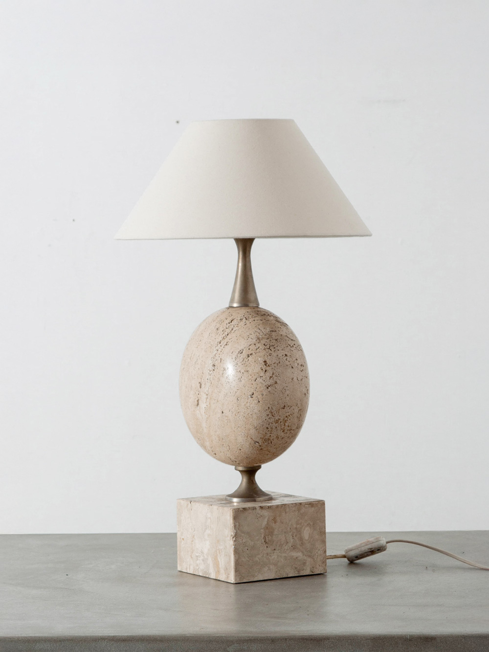 Table Lamp by Philippe Barbier for Maison Barbier in Travertine and Steel
France , 1970s
フランスのデザイナー Philippe Barbier（フィリップ・バルビエ）によって、自身が経営するアトリエ Maison Barbier のためにデザインされたテーブルランプ。
優雅な曲線のトラヴァーチンや磨き上げられた金属のベースを特徴とする、彫刻的なデザインが印象的な作品。
当時の映画監督たちの注目を集め、数々のフランス映画のセットで使用されております。
