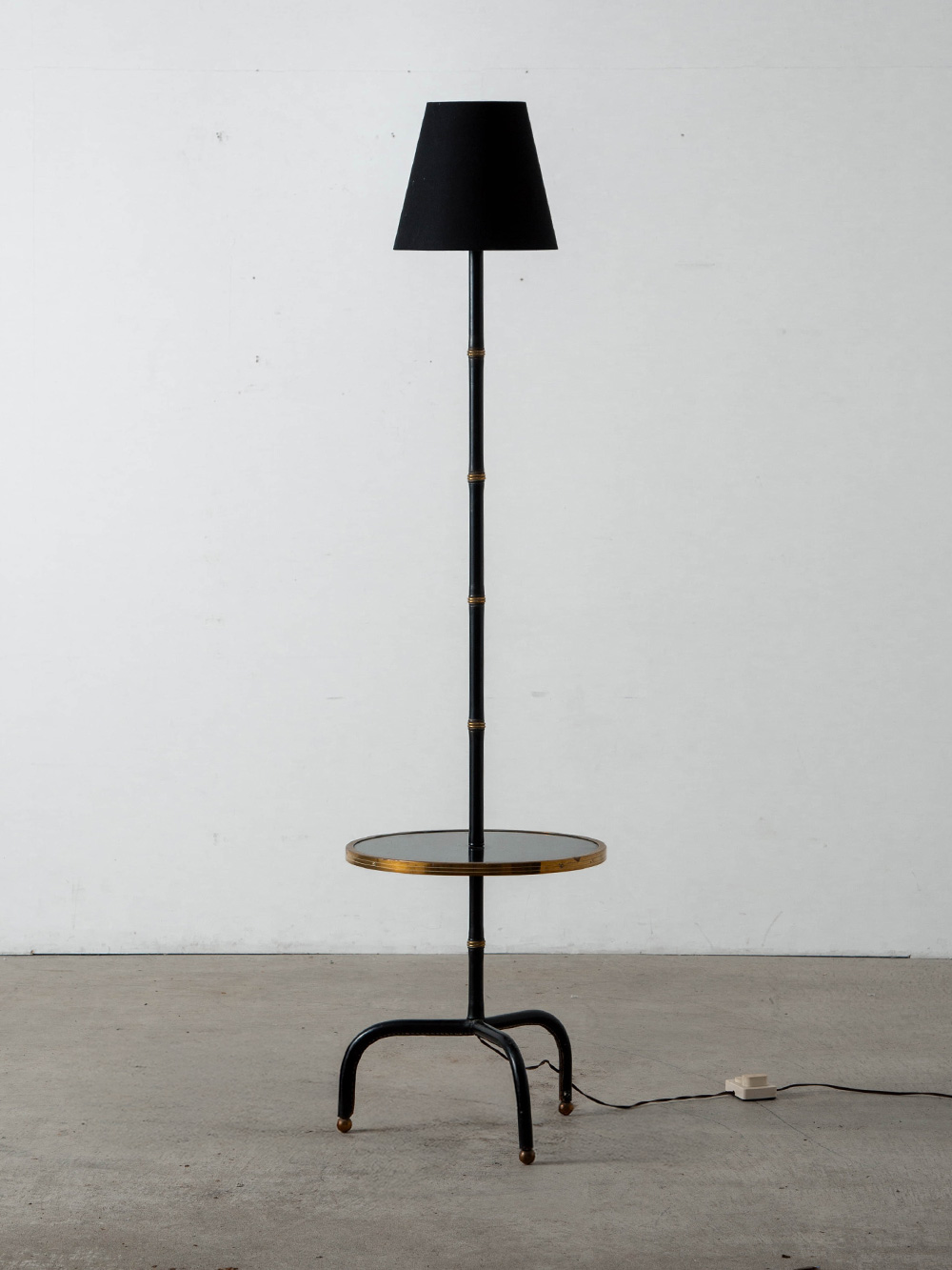 Floor lamp by Jacques Adnet in Wood , Steel and Brass
France , 1940s
フランスの建築家,デザイナーである Jacques Adnet（ジャック・アドネ）によってデザインされたフロアランプ。
30～50年代のフランスで活躍したアールデコ期における重要デザイナーのひとりであるアドネは、エルメスで家具デザインを手掛けるなど素晴らしい実績を残しています。また、高い統率力で自身の会社 French Art Company の経営者としてもその才能を発揮しました。
本品には、そんな彼のシグニチャーでもある、レザーと真鍮製のリングによる竹を模した美しい意匠が施されています。
