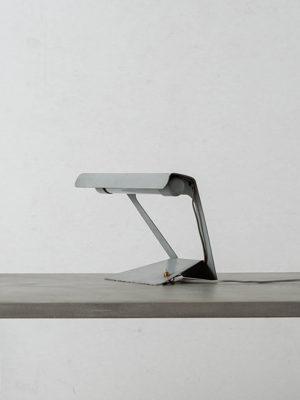 Desk Lamp by Charlotte Perriand for Philips in Steel
France , 1960s
フランスの建築家・デザイナー Charlotte Perriand（シャルロット・ペリアン）によって、オランダの Philips（フィリップス）社のためにデザインされたデスクランプ。
一枚の金属板から曲げ加工とカットによって成形され、グレーのエナメル仕上げが施されたミニマルなデザインが特徴です。

