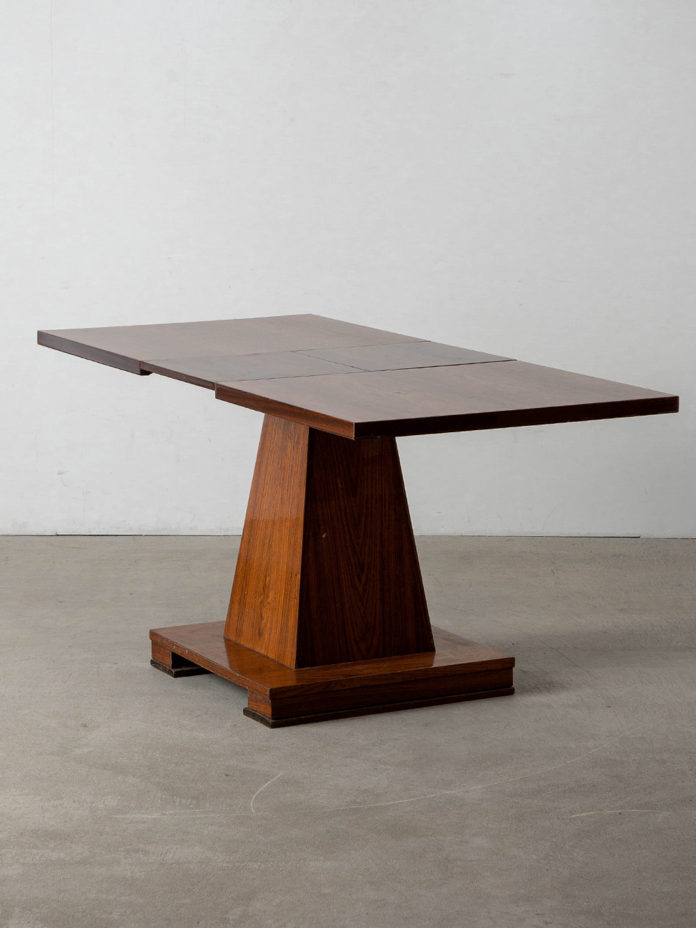 Extension Dining Table in Wood
Italy , 1960s
イタリアより、流麗な木目と鏡面仕上げの調和が美しい天板と、重厚感のある建築的なベースを備えたダイニングテーブル。
天板の中央部分を拡張することができ、エクステンション仕様としてもご使用いただけます。
