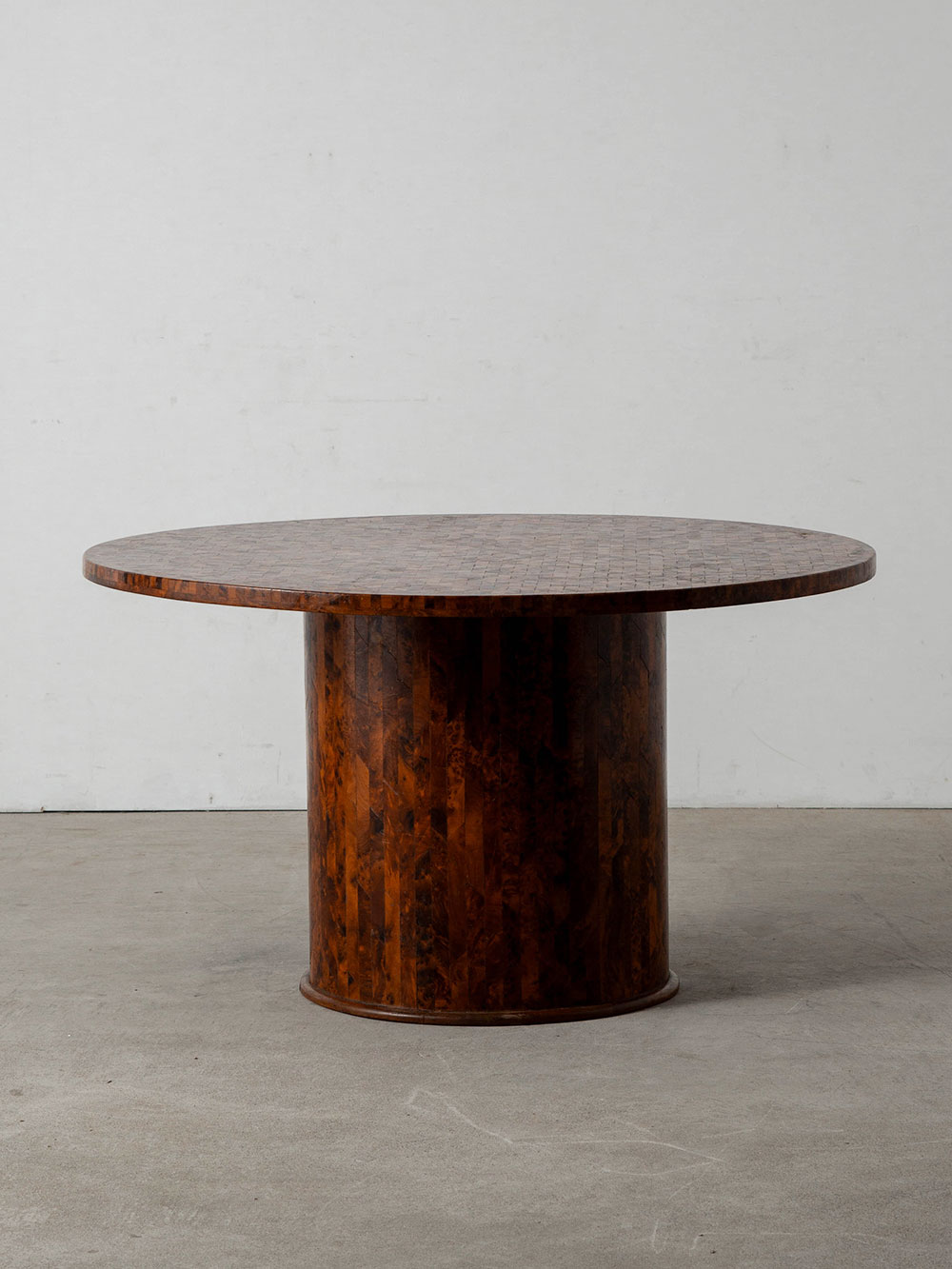 Coffee Table in Wood
Italy , 1960s
イタリアより、細かな木片を貼り合わせた豊かな木目が印象的なコーヒーテーブル。
木目の向きや色調が複雑に重なり合うことで奥行きのある表情を生み出し、厚みのある円形天板とボリュームのある円柱ベースが、落ち着きのある佇まいを演出しています。

