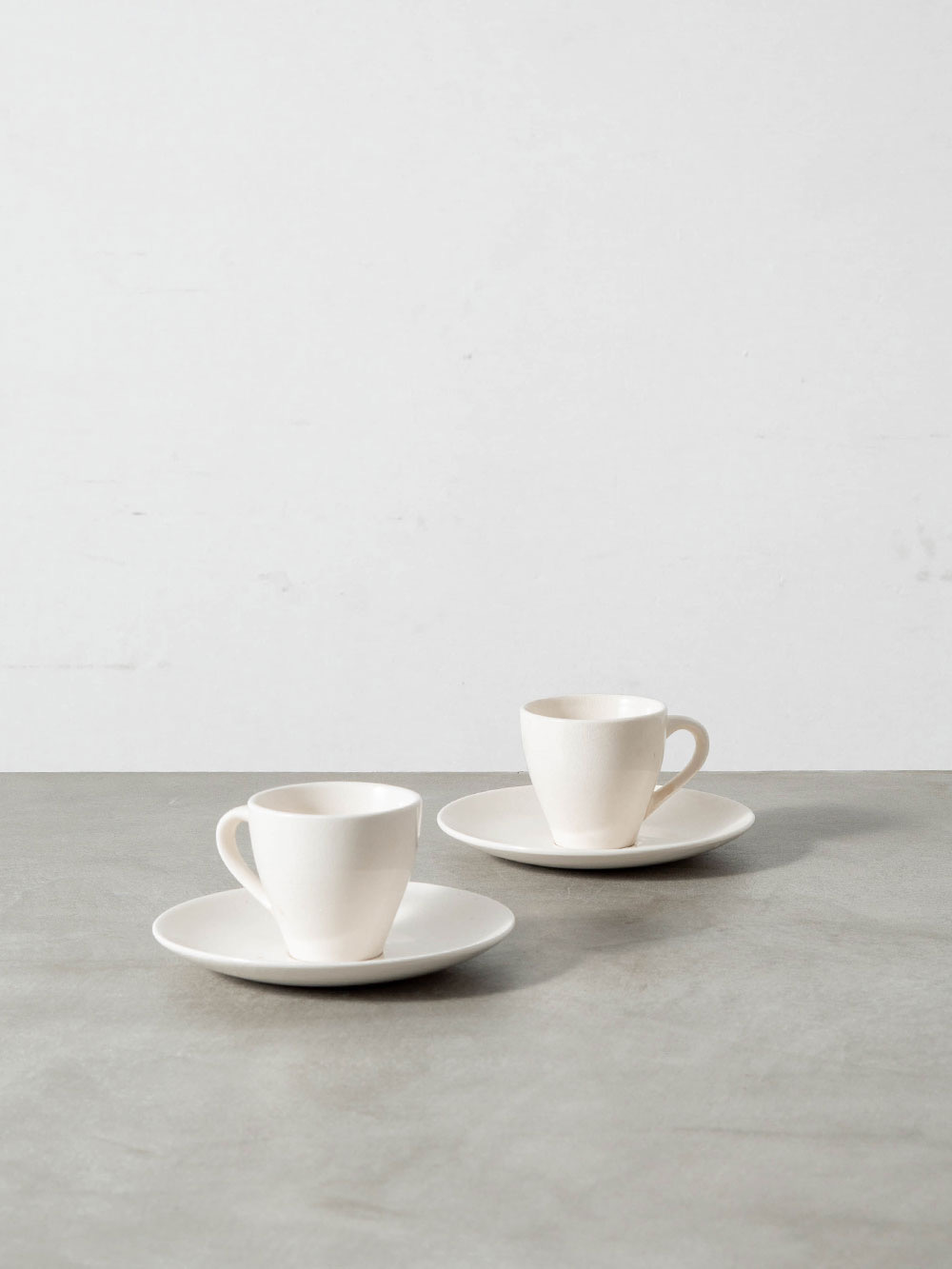 Coffee Cup & Saucer Set by Sori Yanagi for Matsumura & Co in Ceramic
Japan , 1940s
日本を代表するインダストリアルデザイナー Sori Yanagi（柳 宗理）によって、Matsumura & Co（松村硬質陶器株式会社）のために1948年にデザインされた「松村硬質陶器シリーズ」のカップ & ソーサーセット。
装飾を削ぎ落とした端正なフォルムは、戦後日本のモダンデザインを象徴する初期のテーブルウェアとして知られ、1990年にはニッコーよりボーンチャイナで復刻されるなど、現在も高い評価を受けています。
