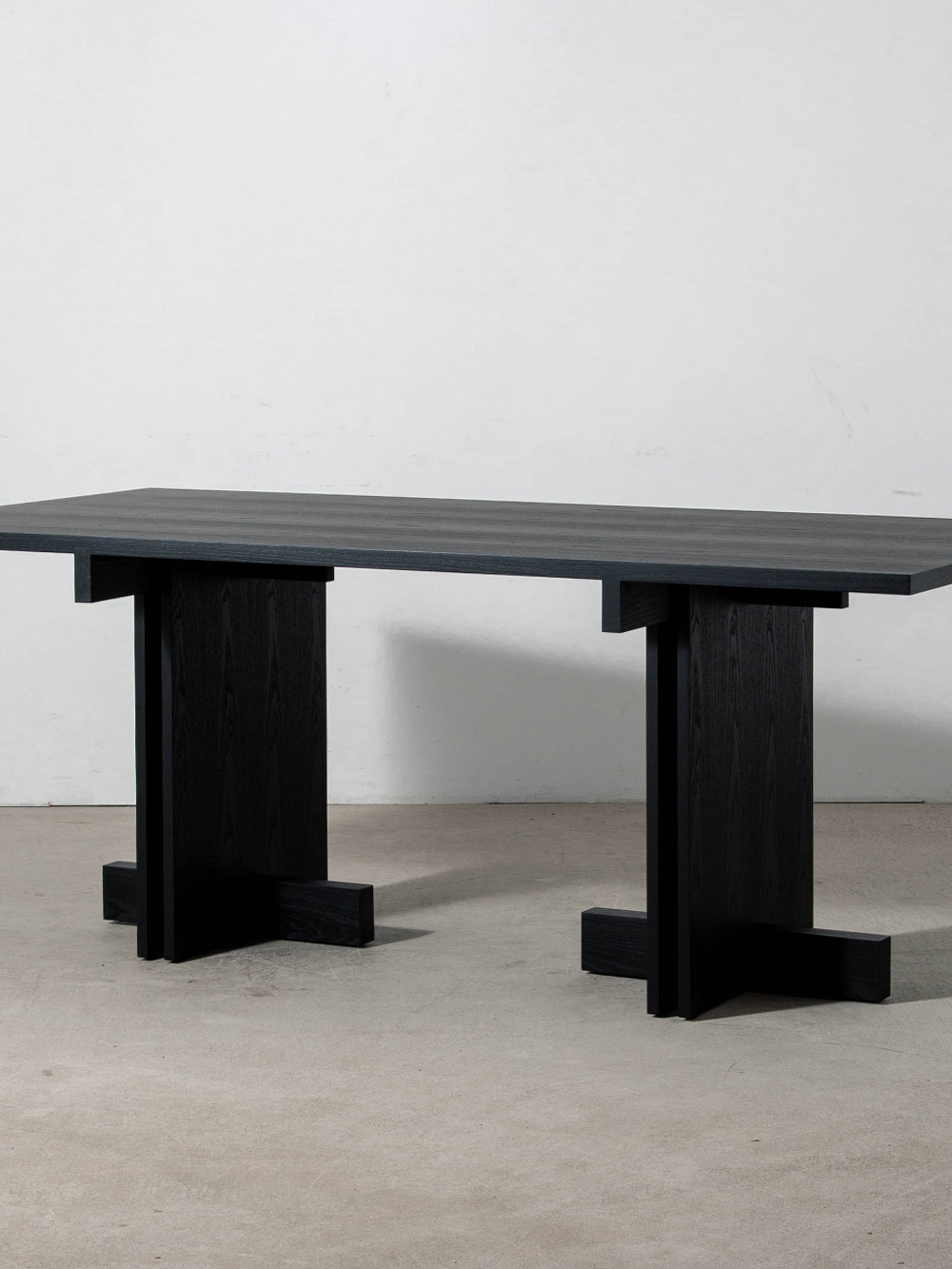 Rak Bistro Table by Francesc Rifé for Kendo in Black Ash
Spain , 2000s
スペインのデザイナー Francesc Rifé（フランセスク・リフェ）によって、2023年にデザインされた Rak（ラック）ビストロテーブル。
Rakシリーズは合理主義建築の思想を現代的に解釈し、明快なラインと重なり合う平面の建築的なフォルムが印象的なコレクションです。
「ビストロ」の名の通り、食事を楽しむダイニングテーブルとしてゆとりのあるサイズ感を備えた長方形テーブル。家族やゲストと囲む食卓はもちろん、広々としたワークスペースとしても活躍します。
素材にはアッシュ材を使用し、職人の手仕事によって丁寧に仕上げられています。
