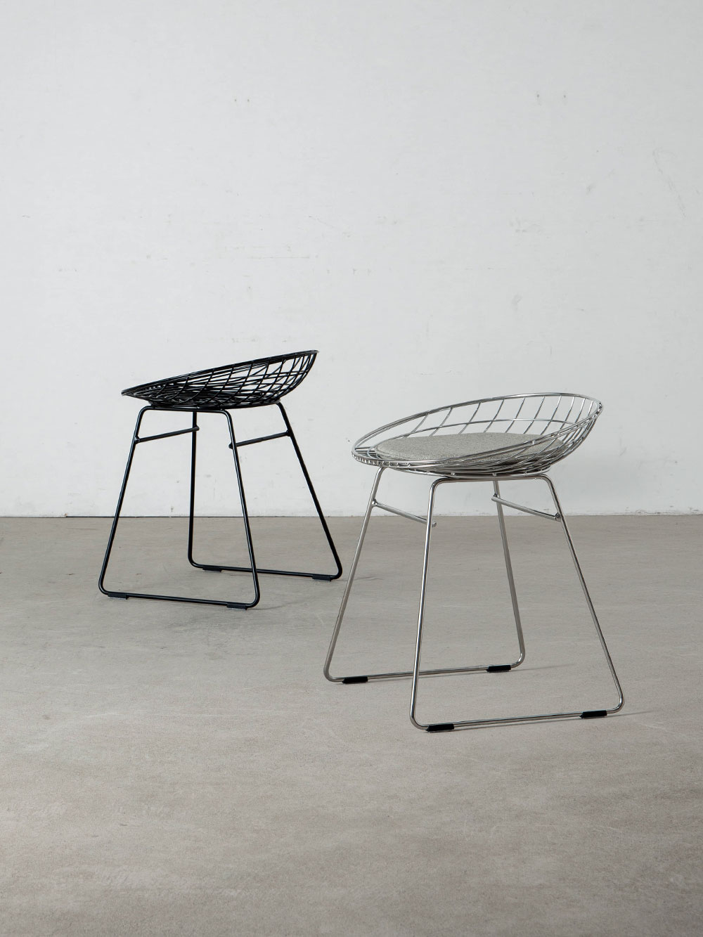 KM05 Wire Stool and Cushion by Cees Braakman for Pastoe
Netherlands , 1950s
オランダ人デザイナーの Cees Braakman （ケース・ブラークマン）によって、1958年にデザインされた KM05 ワイヤースツール。
1950年代、オランダ家具には新たなデザイン思想と工業技術が取り入れられ、スチールワイヤーを用いた家具がモダンデザインの象徴として注目を集めました。
このワイヤーシリーズは当時を代表する一脚であり、細いスチールワイヤーによるフレームは強度を保ちながらも軽やかな印象を与えています。
緻密に計算されたプロポーションと緩やかにカーブした座面によって、見た目以上の座り心地を実現。
オリジナルデザインは1958年 Spectrum社から発表され、現在は Pastoe社によって製造されています。
