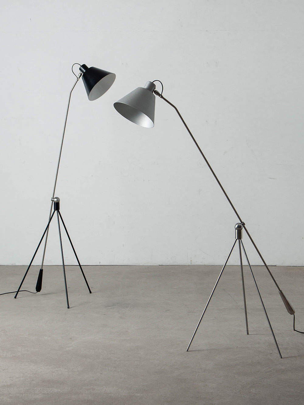 Magneto Floor Lamp by Henk Fillekes for Pastoe
Netherlands , 1950s
オランダ人デザイナー Henk Fillekes （ヘンク・フィレケス）によって、1954年にデザインされた Magneto（マグネート） フロアランプ。
ランプ名の由来である、三脚ベースに取り付けられた磁石のボール構造が特徴。
アームとシェードをスムーズに回転でき、用途に合わせて自由にライティングを調整可能です。
光源をシェードの奥深くに配置することで眩しさを抑え、読書灯としても優れた機能性を備えています。
バウハウス運動から着想を得たミニマルなデザインは、オランダデザインを代表する名作照明として知られています。
オリジナルは1954年に Atelier Artiforte（アトリエ・アルティフォルテ）社のためにデザインされ、現在は Pastoe社によって展開されています。
