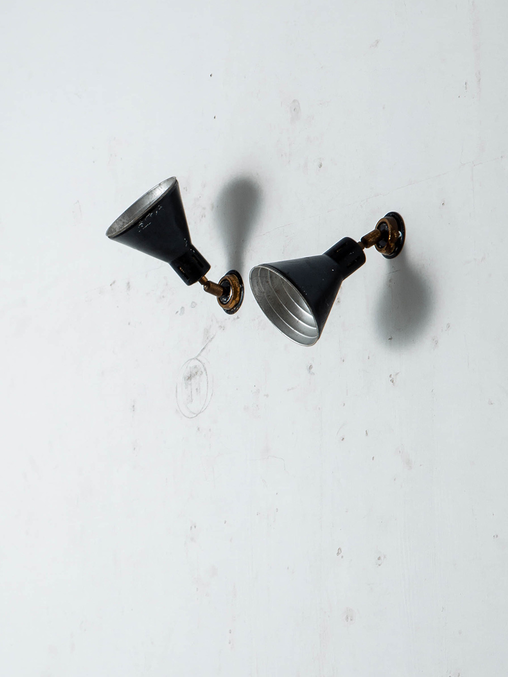 Wall Lamp in Metal and Brass
Italy , 1960s
イタリアより、ブラックに塗装された円錐形のシェードと真鍮のジョイントを組み合わせたウォールランプ。
シェードの角度を調整できる可動式の構造と、ブラックと真鍮のコントラストが美しいデザインです。

