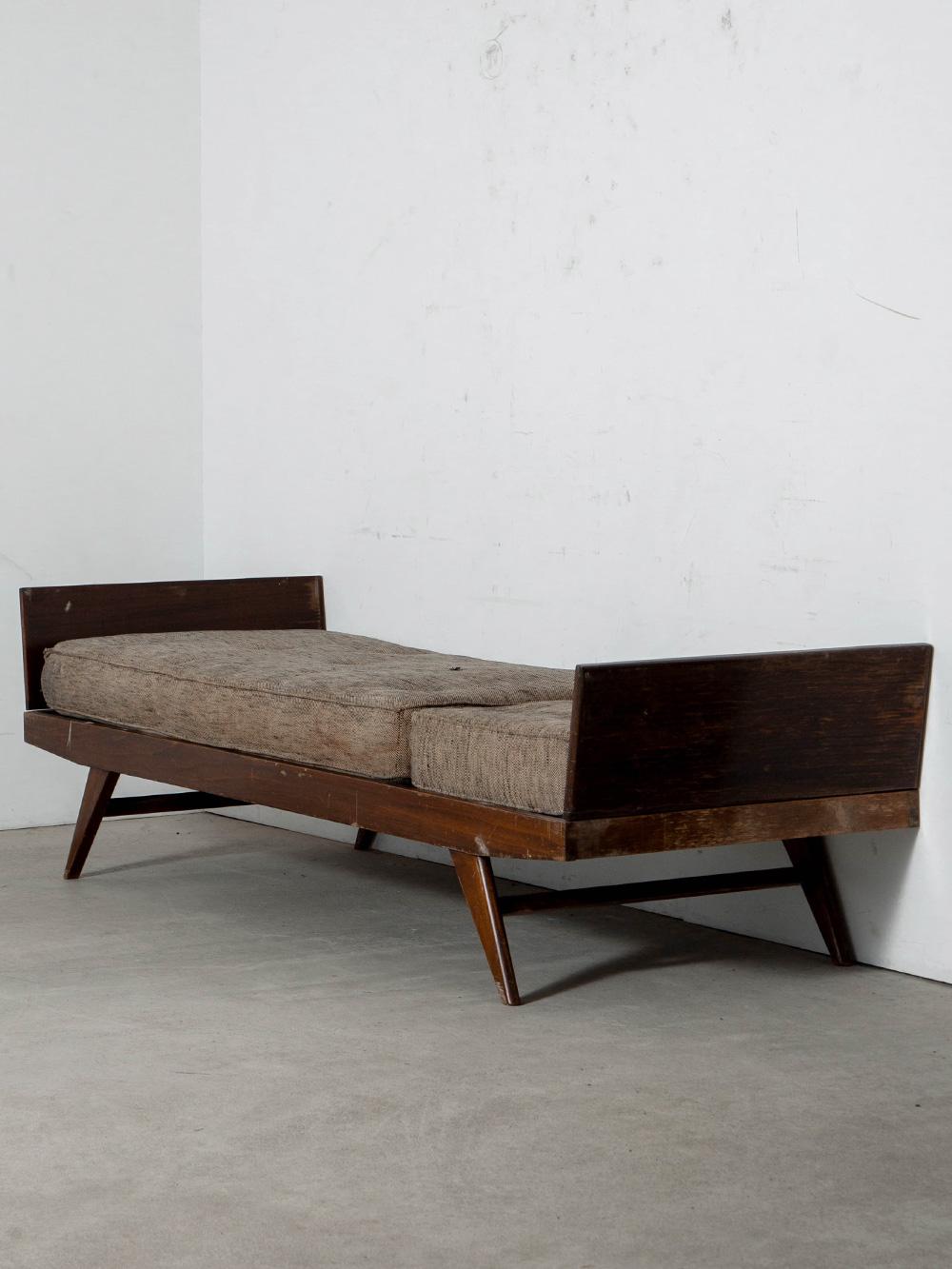 Day Bed by Pierre Guariche for Free Span in Wood and Fabric
France , 1950s
フランス人デザイナー Pierre Guariche（ピエール・ガーリッシュ）によって、同国の Free-Span（フリー・スパン）社のためにデザインされたデイベッド。
外側に開いたコンパスレッグが軽快なシルエットを生み出し、左右のサイドテーブルには収納や変形のための開閉・可動ギミックを備えています。
限られた住空間の中で快適性と機能性を両立するための工夫が随所に見られる一台です。
