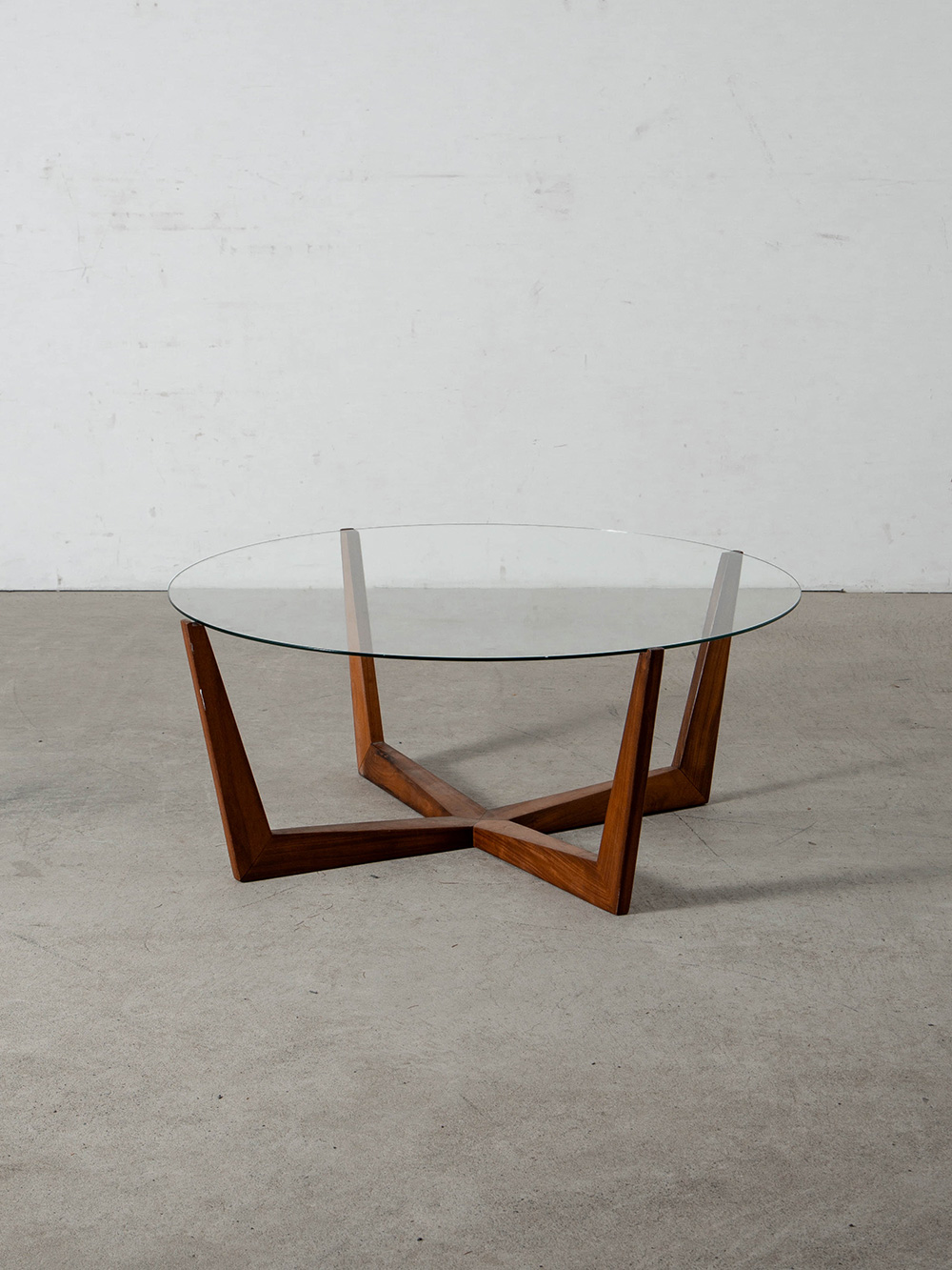 Coffee Table in Glass and Wood
Brazil , 1970s
ブラジルより、中央で交差する木製フレームから放射状に伸びる4本の脚と、鋭角なフォルムが調和した彫刻的なコーヒーテーブル。
